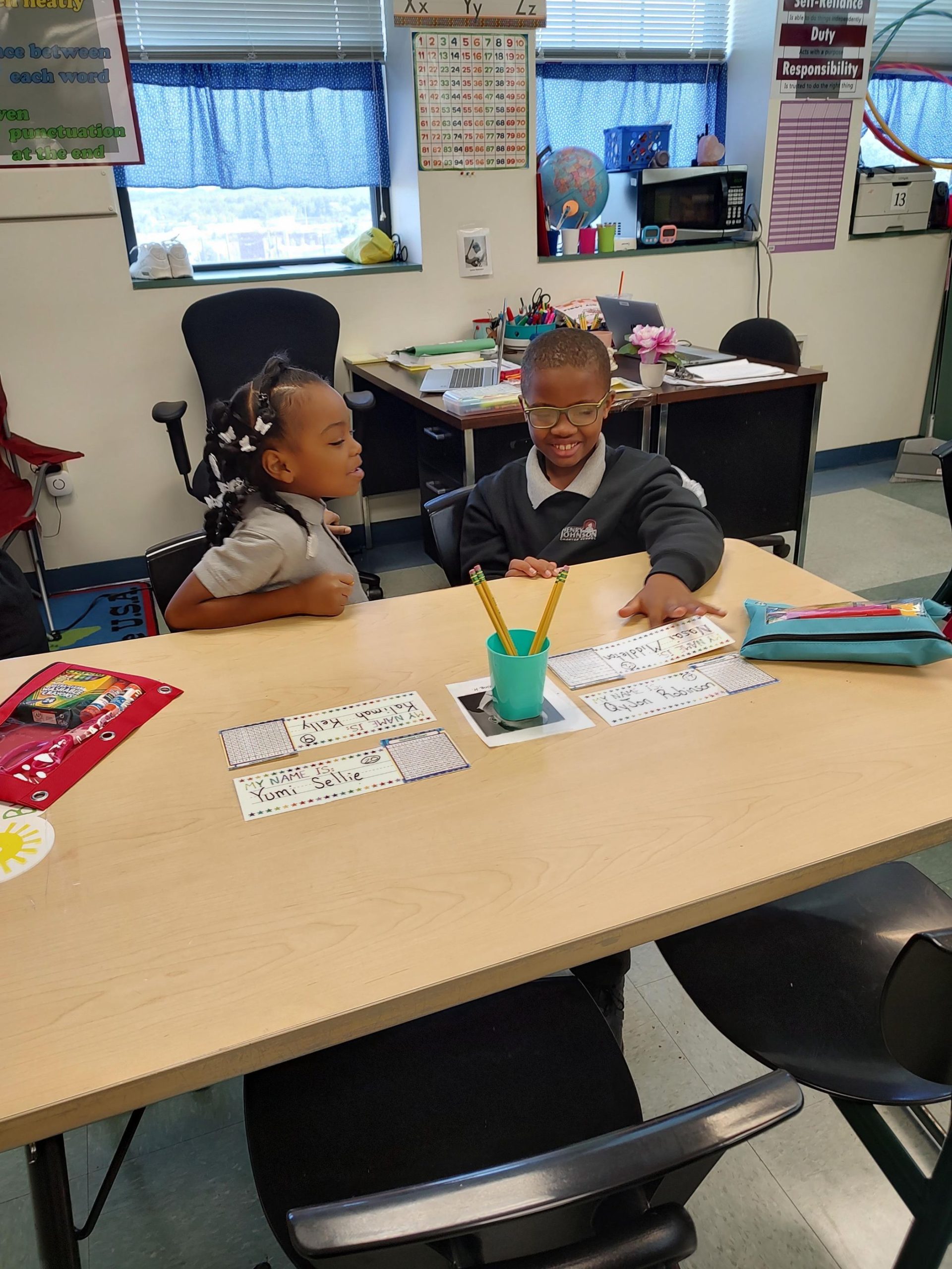 Two children sitting at a desk learning